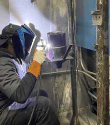 welder in lab cutting metal