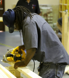 student sawing boards in lab