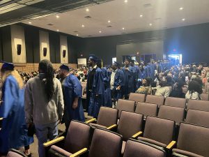 NATS graduates lining up and walking toward the front of auditorium