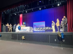 Staff and faculty standing on graduation stage