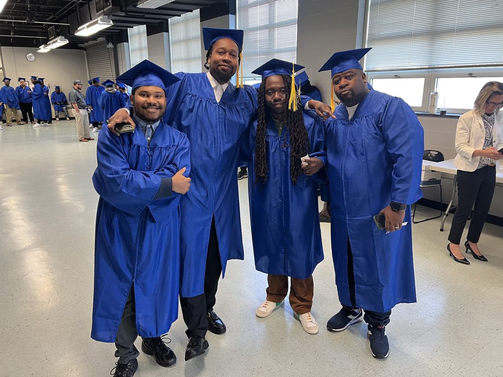 Four graduates smiling