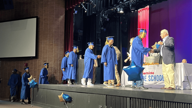 NATS graduates walking across stage and accepting diploma