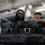 Two students leaned over trunk