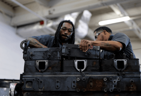 Two students leaned over trunk