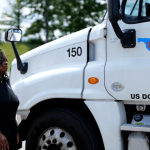 Closeup of NATS white semi truck cab with instructor standing in front