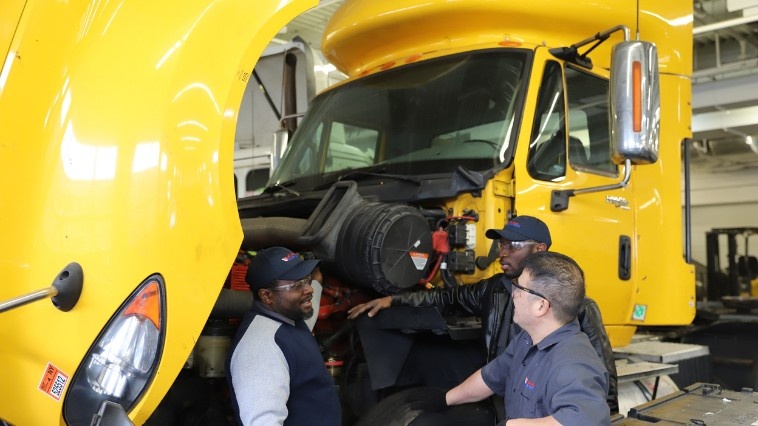 Students looking into the engine of semi truck