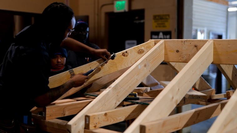 Student working on constructing with wood beams