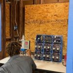 Student working on an electrical panel at trade school